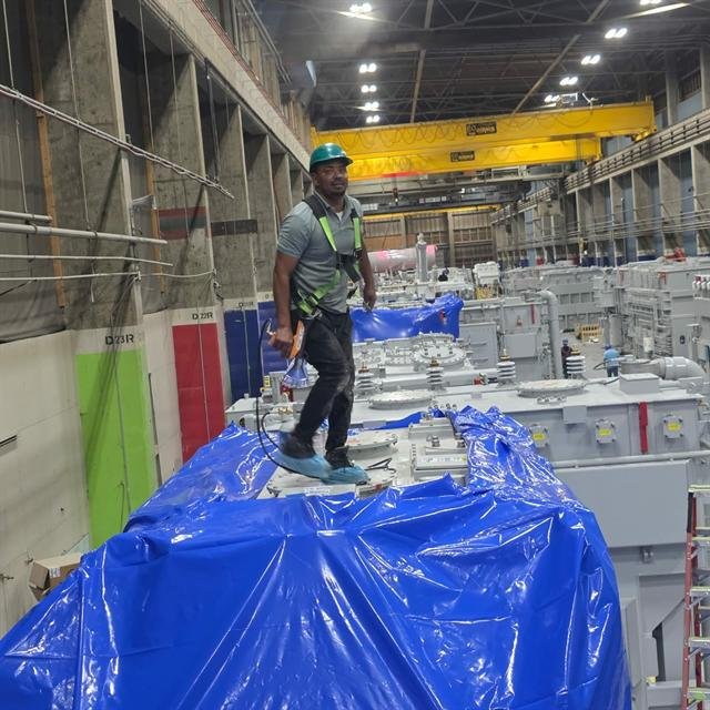 Armstrong technician heat-sealing shrink wrap on a transformer inside a plant